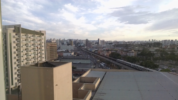 Vista do quarto do hotel, com prédios, carros, metrô e CT Novatec no fundo.